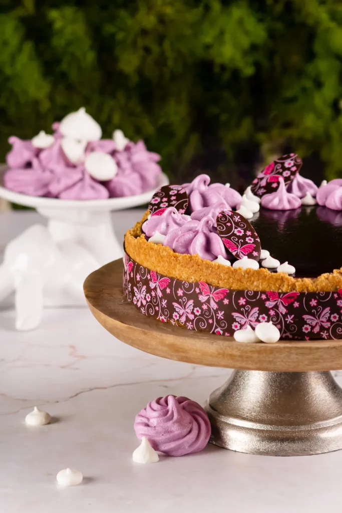 Wegańskie ciasto mazurek na paterze ozdobiony bezikami i czekoladą