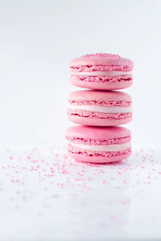 Różowe makaroniki na błyszczącej podstawie i z różowym cukrem