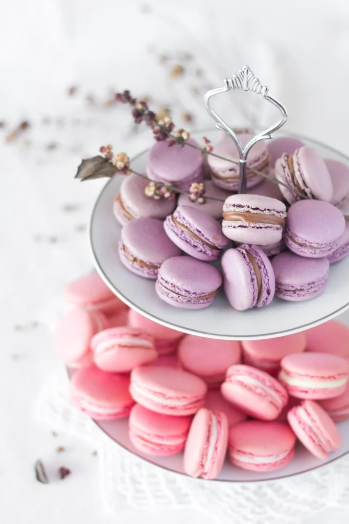 Fioletowe i różowe makaroniki na białej piętrowej paterze