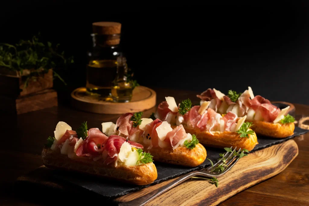 Eklery z szynką parmeńską na drewnianej desce