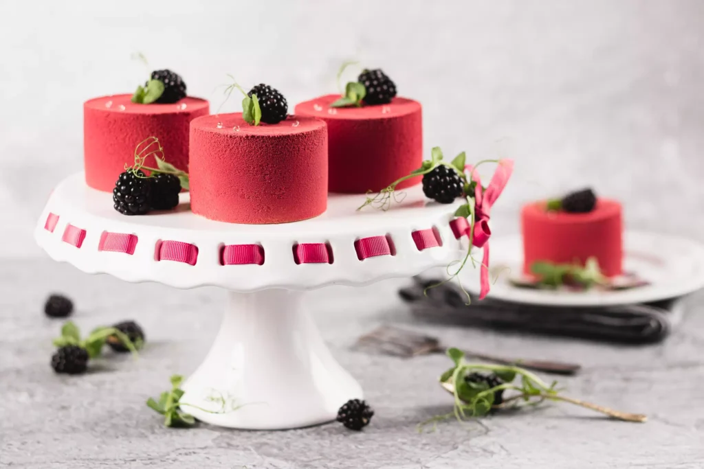 Czerwone desery na paterze z jeżynami i ziołami