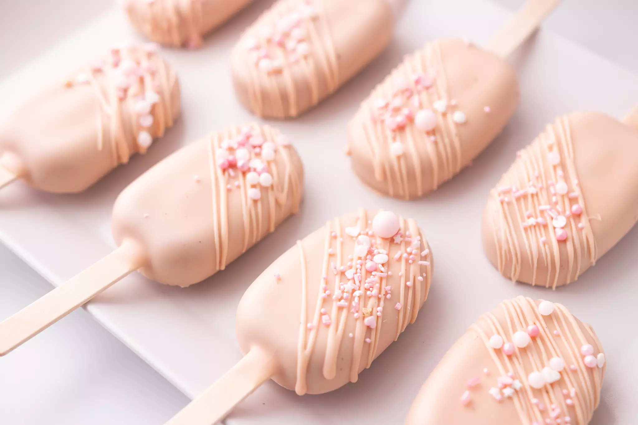 Cakesicles malinowe z posypką jako deser na weselny i komunijny candy bar